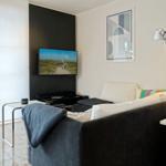 A living room with sofa, TV, and floor lamp.