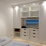 Bedroom with white closet, TV, and bed with towels.