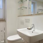 Bathroom with sink, toilet, and mirror cabinet