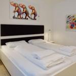 Bedroom with double bed, white linens, and wall art.