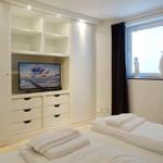 Bedroom with bed, TV, and window with curtains.
