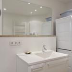 Bathroom with washing machine and dryer, mirror cabinet and sink.