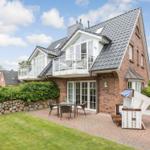House with balcony, terrace and garden. White furniture and stone wall.