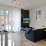 Living and dining area with sofa, TV, and terrace door.
