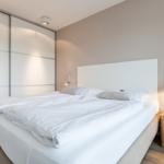 Bedroom with double bed, sliding doors, and wall art.
