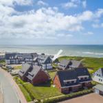 Coastal village with houses and beach. Aerial view of the seaside landscape.