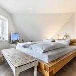 Bedroom with wooden bed, window, and TV.
