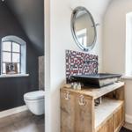 Bathroom with sink on wooden console, mirror, and window