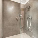 Shower cabin with glass enclosure and modern shower fixtures.