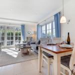 Wohn- und Essbereich mit Tisch, Stühlen, Sofa und Blick auf Garten