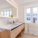 Badezimmer mit Doppelwaschbecken, Spiegel und Fenster