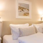 Schlafzimmer mit Bett, Kissen und Wandbild an der Wand.