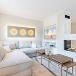 Wohnzimmer mit Sofa, Kamin und Fernseher an der Wand.