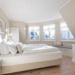 Schlafzimmer mit Doppelbett, Fensterbank und Fernseher