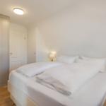 Schlafzimmer mit Doppelbett, Nachttischen und Kleiderschrank.