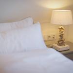 Schlafzimmer mit Bett, Nachttisch und Lampe aus Muscheln.