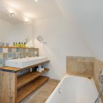 Badezimmer mit Badewanne, Waschbecken und Spiegel