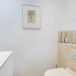 Badezimmer mit Waschbecken, Toilette und Fenster