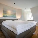 Bedroom with bed, wall art, and window