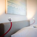 Bed head with red lamps and wall art