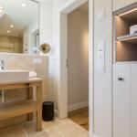 Bathroom with sink, mirror cabinet, and lit shelf