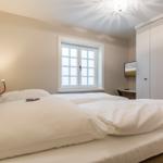 Bedroom with double bed, window, and wardrobe.