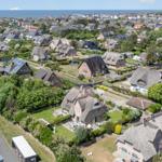 Village with thatched houses and view of the sea