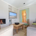 Living room with fireplace, TV, and large wall art.