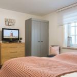 Schlafzimmer mit Bett, Kleiderschrank und Fernseher.