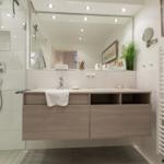 Badezimmer mit Dusche, Waschtisch und Spiegel