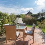 Terrasse mit Sitzgruppe und Blick auf Garten und Haus.