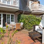 Terrasse mit Sitzgruppe, Strandkorb und Blick auf das Haus.