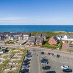 Coastal holiday complex with parking lots and mini golf course.