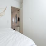 Bedroom with white bed, wardrobe, and wall decoration.