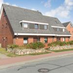 Red brick house with gray roof and windows on street