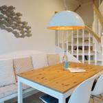 Dining area with wooden table, bench, and wall decor of fish.
