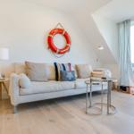 Living room with sofa, lifebuoy on wall, and TV.