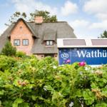 Wohnhaus mit Strohdach und Schild Watthüs im grünen Garten