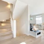 Haus mit Holztreppe und Kamin im Wohnzimmer.