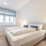 Schlafzimmer mit Doppelbett, Fenster und Nachttisch