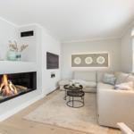 Wohnzimmer mit Kamin, Sofa und Wandbild.