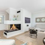 Wohnzimmer mit Kamin, Sofa und Fernseher an der Wand.