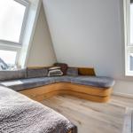Schlafzimmer mit Bett, Sitzbank und Fenstern