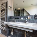 Bathroom with double sink, mirror, and hairdryer.