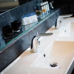 Modern double sink with mirror and black ceramic cups.