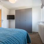 Bedroom with bed, wardrobe, TV, and window.