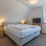 Bedroom with double bed, TV, and window.