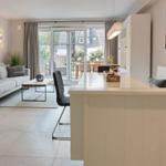 Living and dining area with modern furniture and view of the garden.