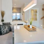 Dining area with white table and bench. Decoration with bird and plant.