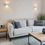 A living room with sofa, coffee table, and lighting.